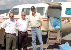 Standing by the supply-laden plane are, from left, William P. 'Scott' Welch, instructor of diesel equipment technology at Penn College%3B Dr. Jay Dennis Hancock of Carilion Health Systems%3B and CitiHope President Paul Moore. 