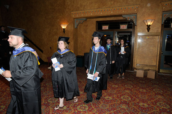 Degree candidates process into the Community Arts Center theater.