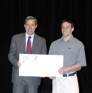 William J. Davis accepts a mockup of his %245,000 winnings from James K. Shillenn, executive director and CEO of the Industrial Modernization Center .