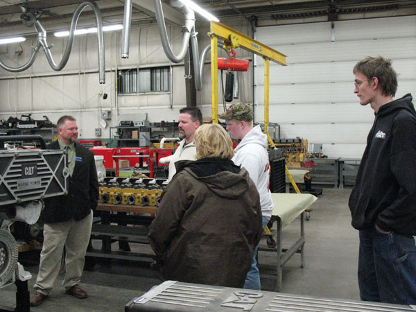 ... and Claude T. Witts, instructor of diesel equipment technology, engages guests with the CAT Marine Power Engine.