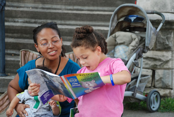 A child shows her mom her new Wildcat coloring book.