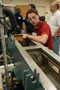 Participant Paul Passerell monitors a string of plastics as it leaves the extruder