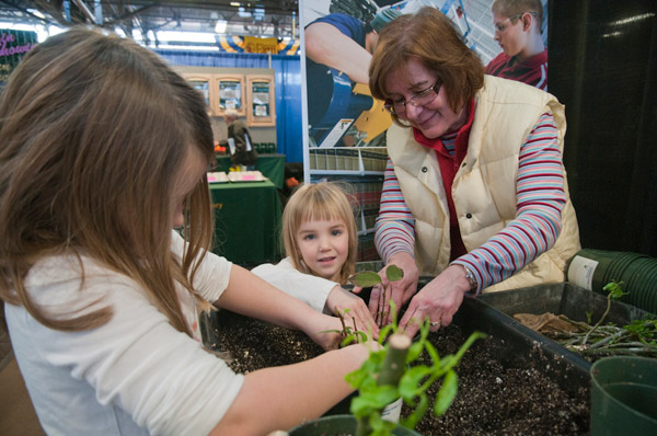 With the help of their grandmother and diesel equipment technology laboratory assistant Seth Welshans (not shown), children prepare root cuttings to take home.