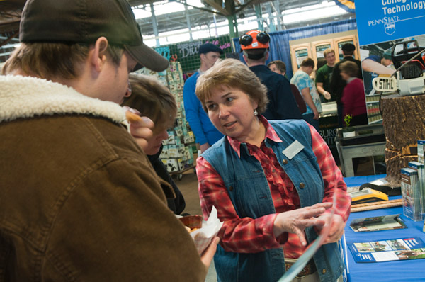 Carol A. Lugg, coordinator of matriculation and retention for the School of Natural Resources Management, discusses Penn College majors with Farm Show visitors.