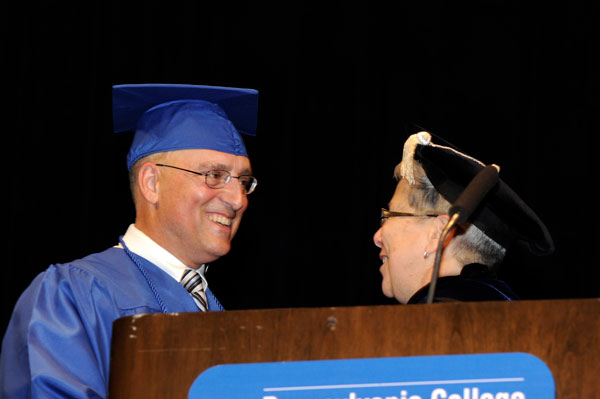 President Gilmour shares a moment with the class representative after turning his tassel to mark his graduation.