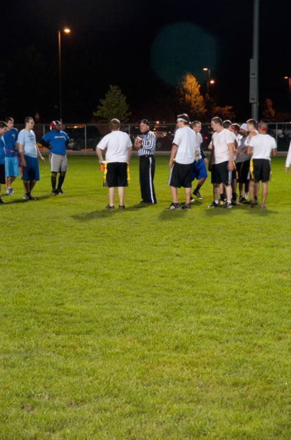 Teams in Thursday night's Homecoming flag football game confer with an official.