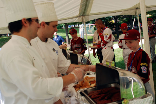 Little Leaguers move through the food-service, filling their plates with the best in picnic fare.