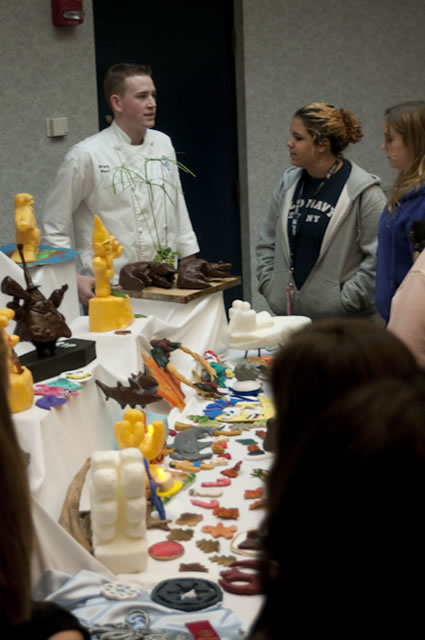 Student William Brady West talks with high schoolers about tallow sculptures.
