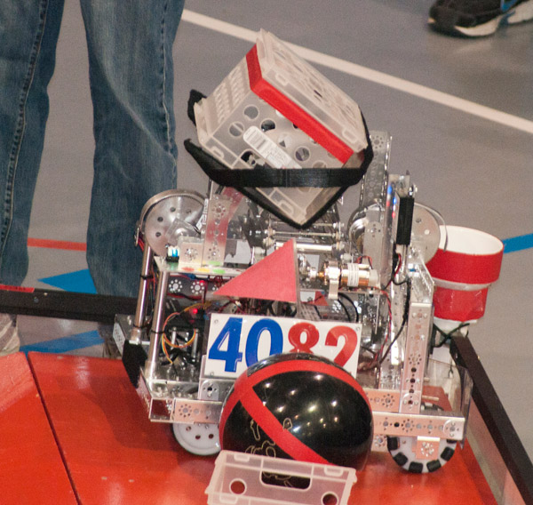 The bot belonging to the RoboSpartan Robotics, of New Hartford, N.Y., brings a basket up the ramp to join a bowling ball it already delivered.
