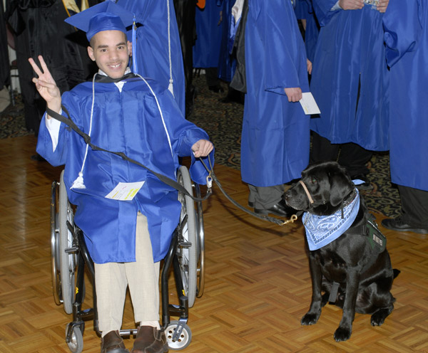 Gabriel M. Brown, who earned an associate degree in mass media communication, with his service dog Einstein