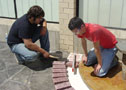 Tyler M. Caldwell, left, and Lucas E. Bridgens install bricks alongside a memorial bench