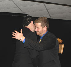 Andrew Wisner, left, and James Riedel share an emotional passing of the gavel.
