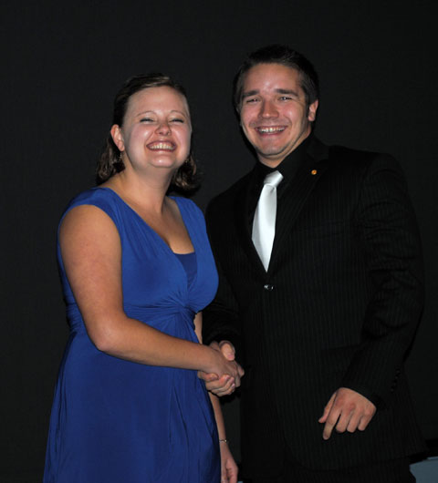 Sigma Pi's Anthony Manjone accepts Greek of the Year honors from Erin M. Datteri.