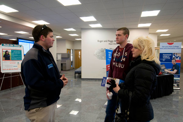 Student Ambassador Gregory J. Miller takes a mother and son through the Madigan Library on a walk across main campus.