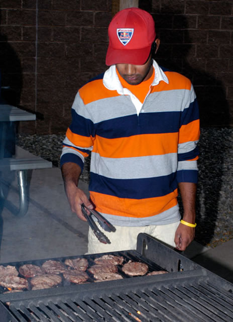Chi Phi's Christopher Kurz works the grill outside Campus View Apartments.