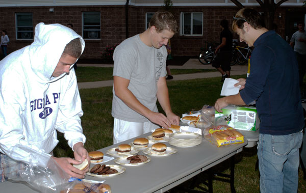 From left, Sigma Pi's John Keenan; and Kyle Reitz and Trey Judy, both of Sigma Nu; serve up the 'burgers and 'dogs.
