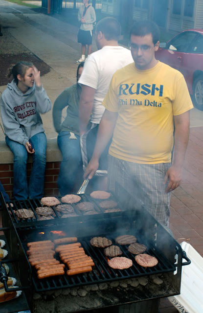 Unfazed by smoky surroundings, Phi Mu Delta's Tony Calabro tends the home fires at The Village.