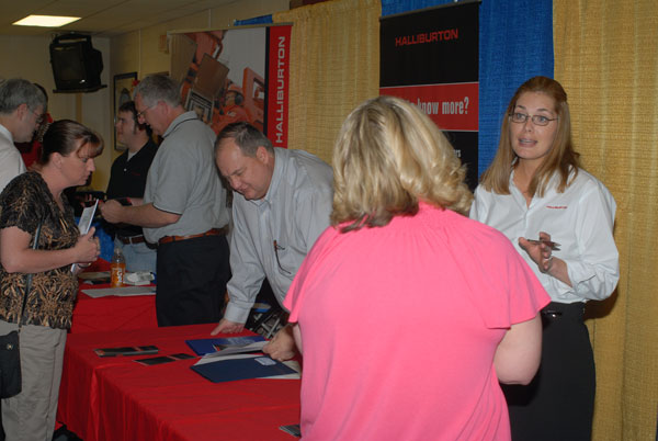 Halliburton human resources representative Ashley Hager and district manager Perry Harris (center) talk with applicants.