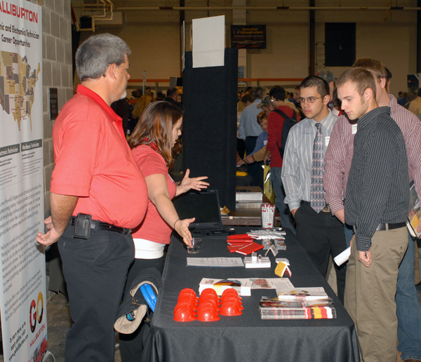 Halliburton Energy Services employees talk with students.