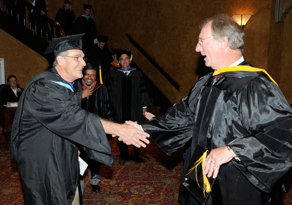 Faculty member Paul A. Babe Mayer shares a hearty handshake with Senior Vice President William J. Martin.