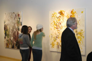 Students and faculty view Timothy Hawkesworth's artwork on display in the Madigan Library gallery.