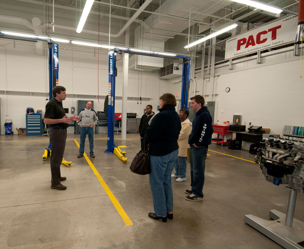 Charles F. Probst, a member of the automotive faculty, talks with visitors to the Honda lab.