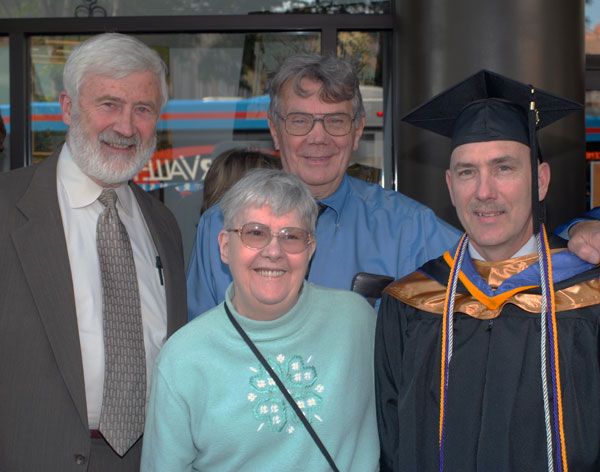 Joseph R. Raup, outgoing president of the Delta Mu Delta honor society, is congratulated by smiling supporters  including his adoptive father, former Lycoming County Judge Thomas C. Raup (left), a 1992 recipient of a Distinguished Part-Time Teaching Award while a legal assistant instructor at the college.