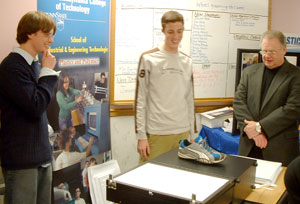 Penn College student Ryan F. Walls, left, gives directions to a Northern Tier student while Robert J. Blair, president and chief executive officer of the Tioga County Development Corp., watches the process.