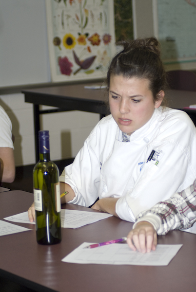 Hospitality Management student Hannah Fisher learns about labeling conventions on German wine bottles during the Wine and Beverage Management course, which was visited by German wine expert Klaus Wahl. The course teaches students the concepts of beverage operations and service concepts, including responsible alcoholic beverage service techniques.