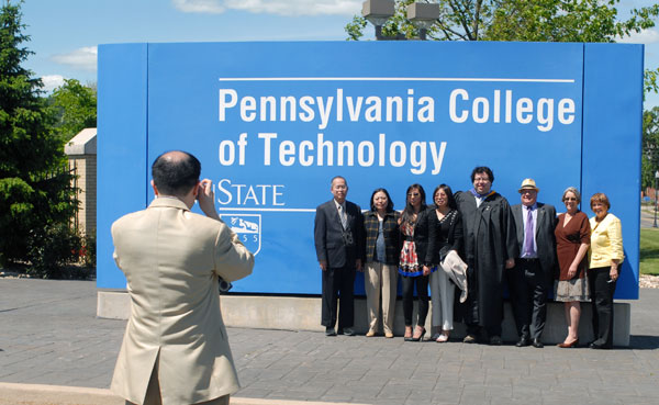 Charles Chang McMorran, who graduated Saturday morning with a bachelor's degree in computer aided product design, gathers with family at a campus landmark.