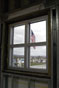 Upper-story window offers view of Old Glory at campus entrance