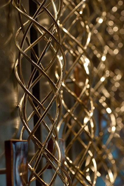A wall fixture shimmers with the woven interplay of art and sunlight.