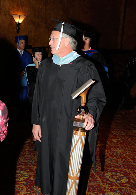 As he has for ceremony upon ceremony, Jim E. Temple carries the academic mace to the stage.
