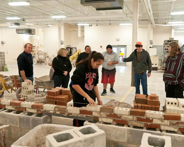 Masonry instructor Richard R. Motter Jr. has fun with visitors during a hands-on exercise in the new Construction Masonry Building.