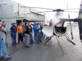 Aviation students, with an MD 500 helicopter