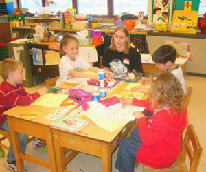 Megan L. Kime of Gardners, president of the Gamma Epsilon Tau graphic-arts fraternity, works with youngsters during an April 13 visit to Lyter Elementary School in Montoursville. (Photo provided by James P. Lentz, associate professor, graphic communications.) 