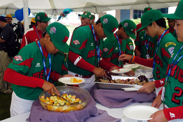 Mexico's players move through the food line, filling their plates with goodies from the college's School of Hospitality.