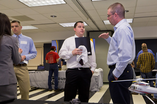 Aviation maintenance technology majors Garrett P. Patterson, of Monroeville (left), and Michael R. Thompson, of Claymont, Del., talk with Sikorsky Global Helicopters representatives Zer Kha and Michael McCook.