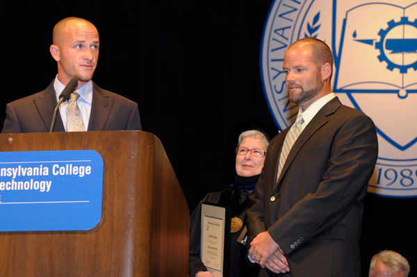 Justin H. Bentz, left, and Travis M. Breininger accept another of the weekend's Alumni Achievement Awards.