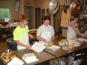 Kirby A. Chaapel, left, works with participants in the kitchens of Central Mountain High School. Chaapel taught a group of teens food-service skills, and the group produced lunch each day for program participants.