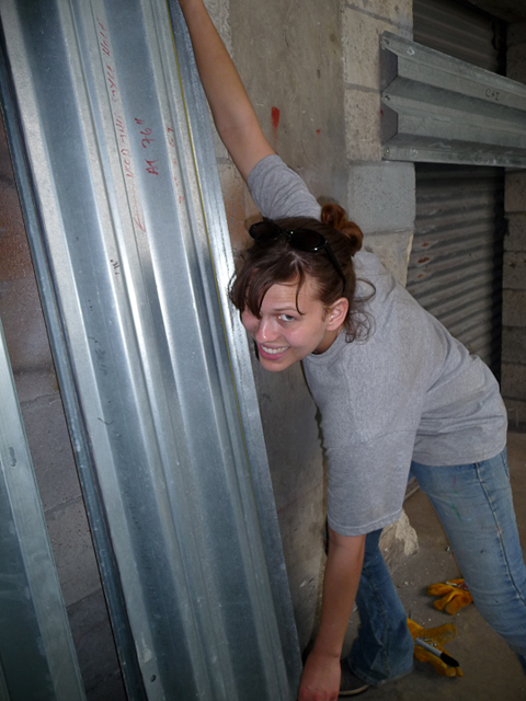 Alyse Poswiatowsky flashes a satisfied smile while moving storm shutters.