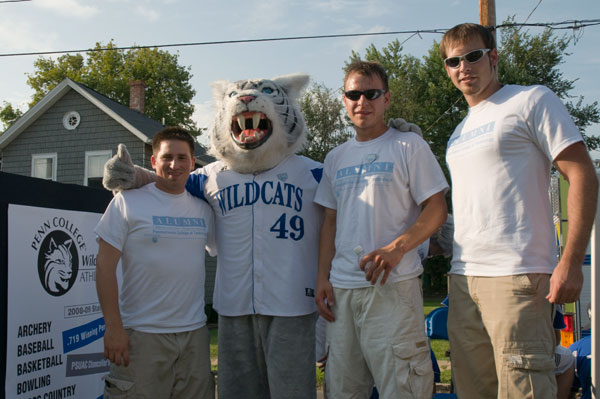 Wildcat baseball alumni Curtis Taylor 05; Paul Hileman, 97; and Austin Upright, 06, join the Wildcat on the parade float.