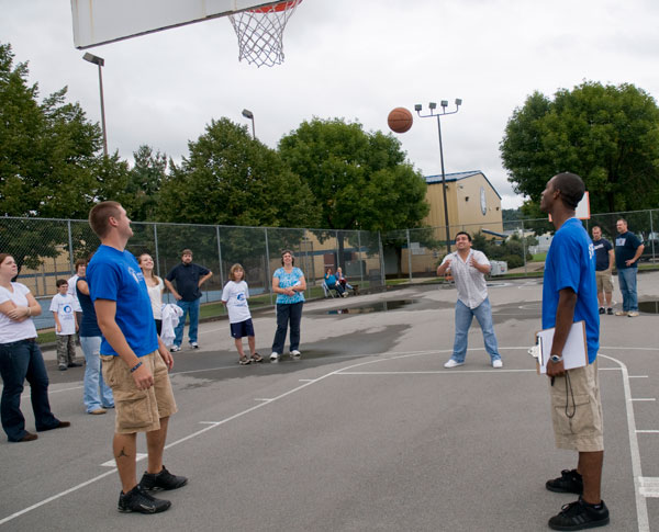 Student-athletes Joseph J. Simon, left, and Tyrone A. Holland watch a father in the Rick Barry Foul Shooting Competition, named in honor of the professional cager with a distinctive underhand free-throw style.