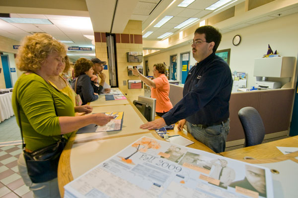 Ruth R. Brewer, information center clerk, and student Matthew L. Valenzuela answer visitors' questions in the Bush Campus Center.