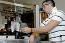 Student pulls a freshly made bottle from the blow-molder