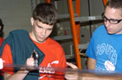 A Penn College plastics student, right, helps a high-school visitor to measure plastic film.