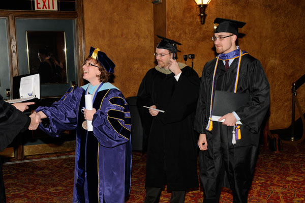 The day's speakers  Christine M. Kessler and Micah A. Metzel  greet other members of the platform party, along with Ward W. Caldwell, special assistant to the president for student affairs (center).