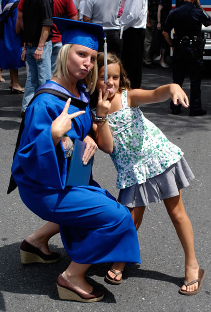 A graduate and her streetwise companion strike a playful stance.