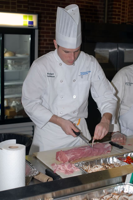 Robert L. Robinson III preps pork for a cooking demonstration later in the week.