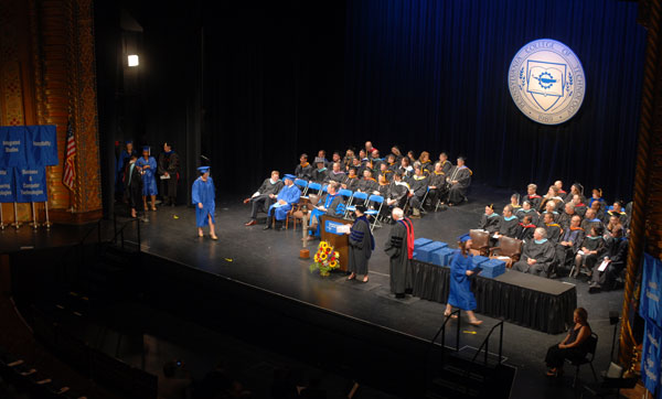 Graduates steadily cross the stage to receive congratulations from President Gilmour and Chairman Dunham.